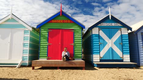 Tourists-walking-and-taking-photo-at-Brighton-Bathing-Boxes,-Melbourne,-Australia