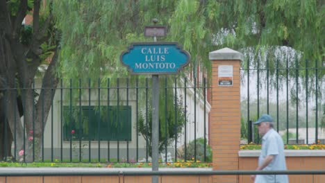 Person-walking-by-Luis-Montoto-street-sign-in-Seville,-Spain,-SLOW-MOTION