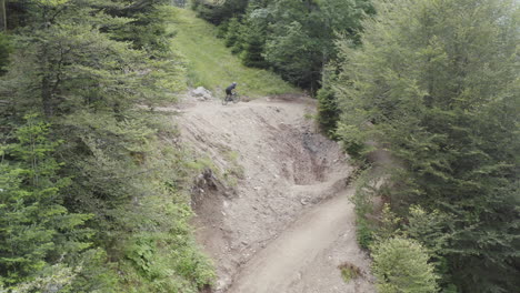 Vista-Aérea-De-Un-Ciclista-De-Montaña-Montando-Cuesta-Abajo-En-Un-Sendero-Para-Bicicletas-En-Las-Montañas-De-Los-Vosgos,-Francia