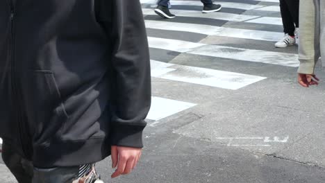 Vista-Panorámica-De-La-Vista-Inferior-Hacia-El-Cruce-De-La-Carretera-Mientras-La-Gente-Cruza-La-Carretera-Durante-El-Día-De-Verano-En-Shibuya,-Tokio,-Japón