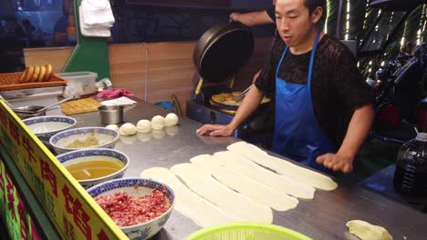 Xian,-China---August-2019-:-Man-making-minced-beef-meat-filled-pastries-in-a-small-local-bakery-on-the-street-in-Muslim-Quarter