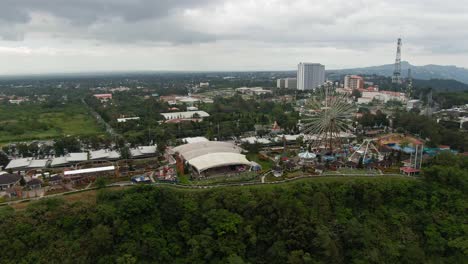 Schöne-Aussicht-Auf-Die-Stadtstruktur,-Themenpark-Oben-Am-Hang-Mit-Dem-Hintergrund-Der-Silhouettenberge-An-Bewölkten-Tagen,-Großes-Riesenrad-Und-Abenteuerfahrt-Auf-Der-Tagaytay-Sky-Ranch