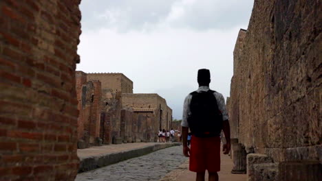 Adult-Male-With-Backpack-Walking-Up-Street-In-Pompeii,-Italy