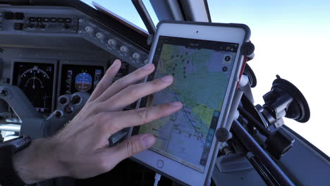 Un-Piloto-Está-Comprobando-La-Ruta-De-La-Aeronave-En-Una-Tableta-Adjunta-A-La-Ventana-De-La-Cabina