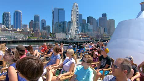 Los-Turistas-Disfrutan-De-Un-Paseo-En-Taxi-Acuático-Con-La-Rueda-De-La-Fortuna-Y-Las-Vistas-De-Seattle-En-Segundo-Plano