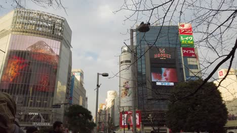 Toma-Panorámica-Lenta-De-Edificios-Que-Cruzan-Shibuya-Con-Anuncios-En-Pantallas-Led