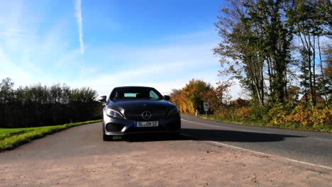 Gris-Mercedes-Benz-Clase-C-Coche-Convertible-Estacionado-Junto-A-La-Carretera-Rural-En-El-Campo-Alemán,-Girando-De-Izquierda-A-Frente