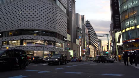 Vista-De-Inclinación-Lenta-Hacia-Abajo-Al-Nivel-De-La-Calle-A-Lo-Largo-Del-Lugar-De-Ginza-En-Japón-Durante-La-Puesta-De-Sol---Toma-Inclinada-Hacia-Abajo