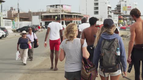 Slow-Motion-120fps---Group-of-surfers-walking-on-the-busy-Peruvian-boulevard-towards-the-point-break