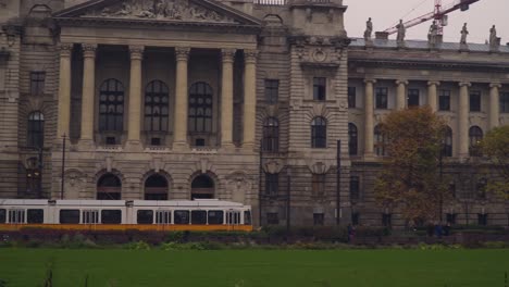 Tranvía-Amarillo-Que-Pasa-Por-La-Plaza-Kossuth-Lajos-Frente-Al-Museo-Etnográfico-En-Budapest-Hungría---Toma-Panorámica