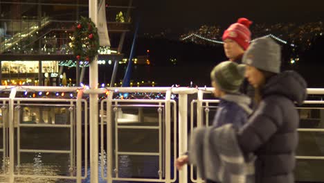 Family-walking-past,-handrail-and-dark-cityscape-backround,-Static