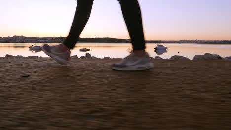 Frauenturnschuhe,-Die-Bei-Sonnenuntergang-Mit-Booten-An-Der-Bucht-Entlang-Spazieren