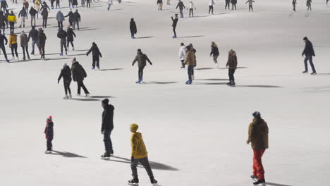 Tiro-De-Barbecho-De-Mano-De-Personas-Patinando-Sobre-Hielo-En-Un-Parque