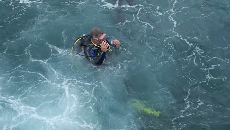 Close-up-of-diver-jumping-into-sea-joining-other-scuba-divers-in-the-port-of-Puerto-Del-Carmen-Lanzarote-Spain