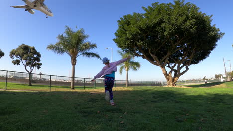 A-little-girl-chases-after-an-airplane-landing-at-Los-Angeles-International-Airport-with-outstretched-arms-in-slow-motion