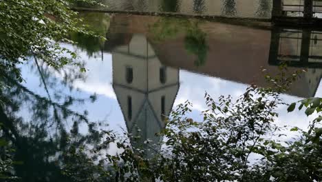 Refelction-of-a-Church-Tower-in-the-Crystal-Clear-Water-of-Blautopf-Lake-in-Blaubeuren,-Swabian-Alb,-Germany