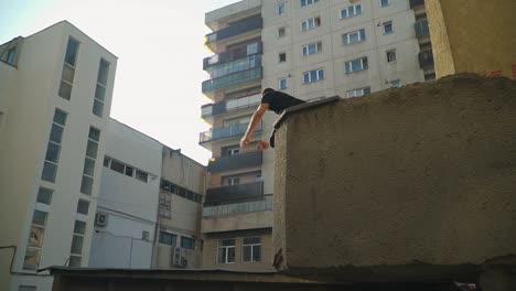 Un-Hombre-Practicando-La-Fuerza-De-Su-Músculo-En-Su-Pierna-Haciendo-Su-Actividad-En-La-Construcción-De-Parkour-En-Cluj-Rumania---Tiro-Ancho