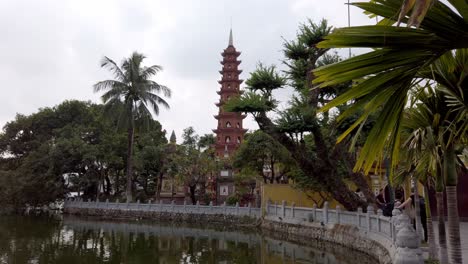 Buddhistischer-Tempel-Tran-Quoc-Pagode-Aus-Dem-Sechsten-Jahrhundert-Mit-See-Und-Touristen,-Stabile-Handaufnahme