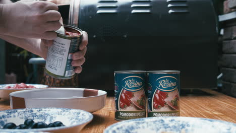 Chef-puts-tomatoes-into-a-plate.-Pizza-making