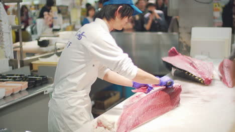 Cortador-De-Pescado-Experimentado-Deshuesando-Un-Gran-Atún-Rojo-Frente-A-La-Audiencia-Pública-En-El-Mercado-De-Pescado-Toretore-Ichiba-En-Wakayama,-Japón---Tiro-Medio