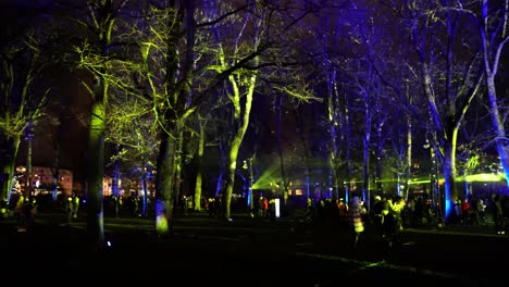 Nach-Rechts-Schwenkende-Aufnahme-Von-Menschen-Auf-Dem-Platz,-Die-Nachts-Die-Lasershow-Bewundern