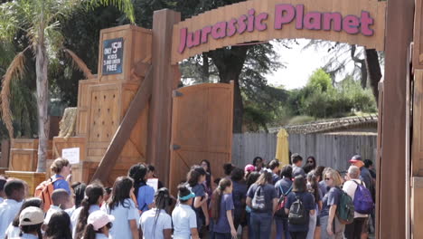 Estudiantes-De-Primaria-En-Viaje-De-Campo-En-Exhibición-De-Dinosaurios,-Ingresando-Al-Planeta-Jurásico,-Cámara-Lenta