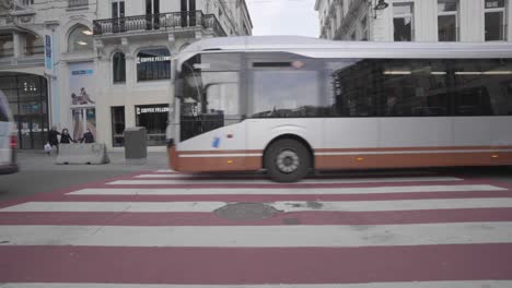 Brussels-traffic-passing-through-a-busy-road-in-front-of-Rue-Neuve-in-Brussels,-Belgium