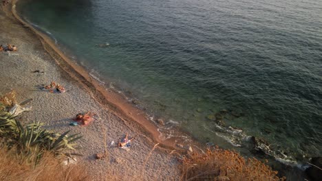 Panning-view-of-small-beach-with-a-bar-on-the-south-end-of-Komiza-on-the-island-of-Vis-in-Croatia