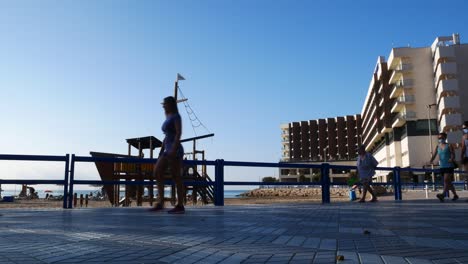 Locked-shot-of-people-walking-with-hygienic-masks-in-front-of-the-beach