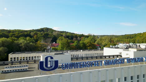 Aerial-flight-over-modern-university-building-sign-in-European-city