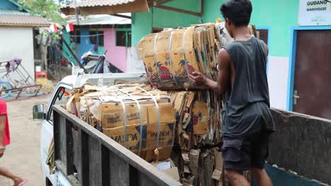 Man-In-Truck-Loading-Piles-Of-Carton-For-Recycling-In-Indonesia---medium-shot