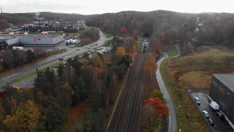 Aerial-view-of-railway-by-industrial-suburban-area-in-Sweden,-daytime