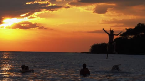 Family-having-fun-in-the-ocean-at-sunset,-and-playing-games-Cropped