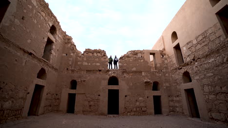 Entrada-Del-Castillo-Del-Desierto-De-Qasr-Kharana-Con-Dos-Turistas-Parados-En-El-Segundo-Piso-Del-Castillo