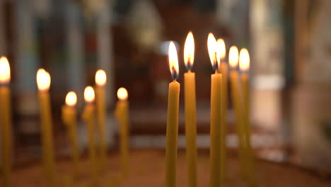 Tiro-Medio-De-Velas-Amarillas-Delgadas-Que-Arden-Con-Una-Luz-Cálida-Y-Encantadora-Dentro-De-La-Iglesia-Ortodoxa-Griega-De-Madaba-St-George,-100-Fotogramas-Por-Segundo