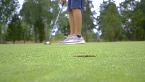 A-man-playing-golf-with-a-putter-and-misses-the-hole