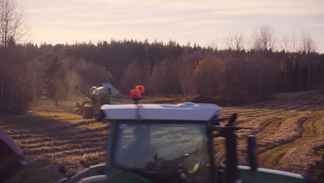 Harvester-machines,-harvesting-on-a-wheat-field,-on-the-countryside,-on-a-sunny-day,-in-Soderhamn,-Sweden