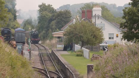 Vintage-train-coming-down-the-tracks-at-Washford-Railway-Station-in-Somerset,-England