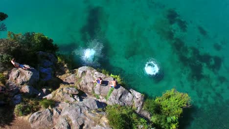 Schwimmer-Springen-Von-Einer-Klippe-Aus-Der-Vogelperspektive-In-Wunderschönes-Klares-Wasser