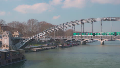 A-large-and-a-small-ship-cross-underneath-the-Viaduc-d'Austerlitz-in-Paris-on-a-sunny-day-at-noon