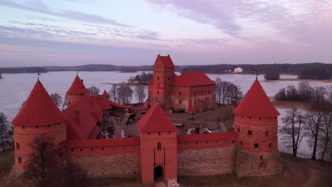 Antena:-Cierre-En-Toma-De-Drones-Del-Castillo-Medieval-De-La-Isla-De-Trakai-De-Estilo-Gótico-Con-Color-Púrpura-De-La-Luz-Del-Atardecer-En-Las-Paredes-Desde-La-Puesta-Del-Sol