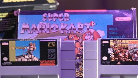 Vintage-Super-Nintendo-Patronen-Mit-Schachtel-Im-Hintergrund-In-Lila-Licht-Nach-Links-Schieben