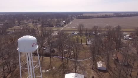 Panorámica-De-Izquierda-A-Derecha-A-Través-De-La-Cara-De-Una-Torre-De-Agua-En-La-Zona-Rural-Del-Sur-De-Illinois-Con-Vistas-A-Las-Tierras-De-Cultivo