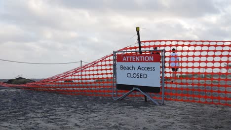 People-ignoring-a-warning-sign-due-to-damage-from-a-developing-cyclone