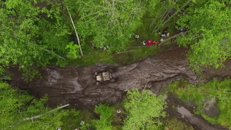 Offroad-mud-rally-with-buggy-in-forests-and-river-aerial-view