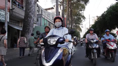 Toma-En-Cámara-Lenta-De-Una-Mujer-Conduciendo-Su-Moto-En-Las-Concurridas-Calles-De-Ho-Chi-Minh,-Vietnam