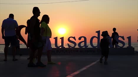 Ich-Liebe-Das-Kusadasi-Wahrzeichenschild-Am-Hafen-Der-Stadt-Und-Die-Touristen,-Die-Darum-Herum-Fotos-Machen