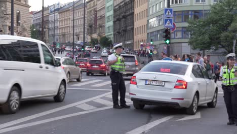 Policías-Controlando-El-Tráfico-Y-Bloqueando-Un-Camino-Con-Un-Coche-De-Policía-Parpadeando-Con-Luces-Azules