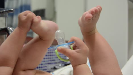 Lindo-Bebé-De-Seis-Meses-Jugando-Con-Maniquí-Y-Sus-Pies-En-El-Baño