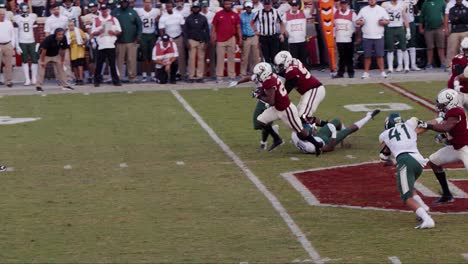 Un-Mariscal-De-Campo-Atrapa-La-Caminata-Y-Le-Entrega-La-Pelota-A-Un-Corredor-Que-Conduce-Por-El-Campo-Para-Un-Touchdown